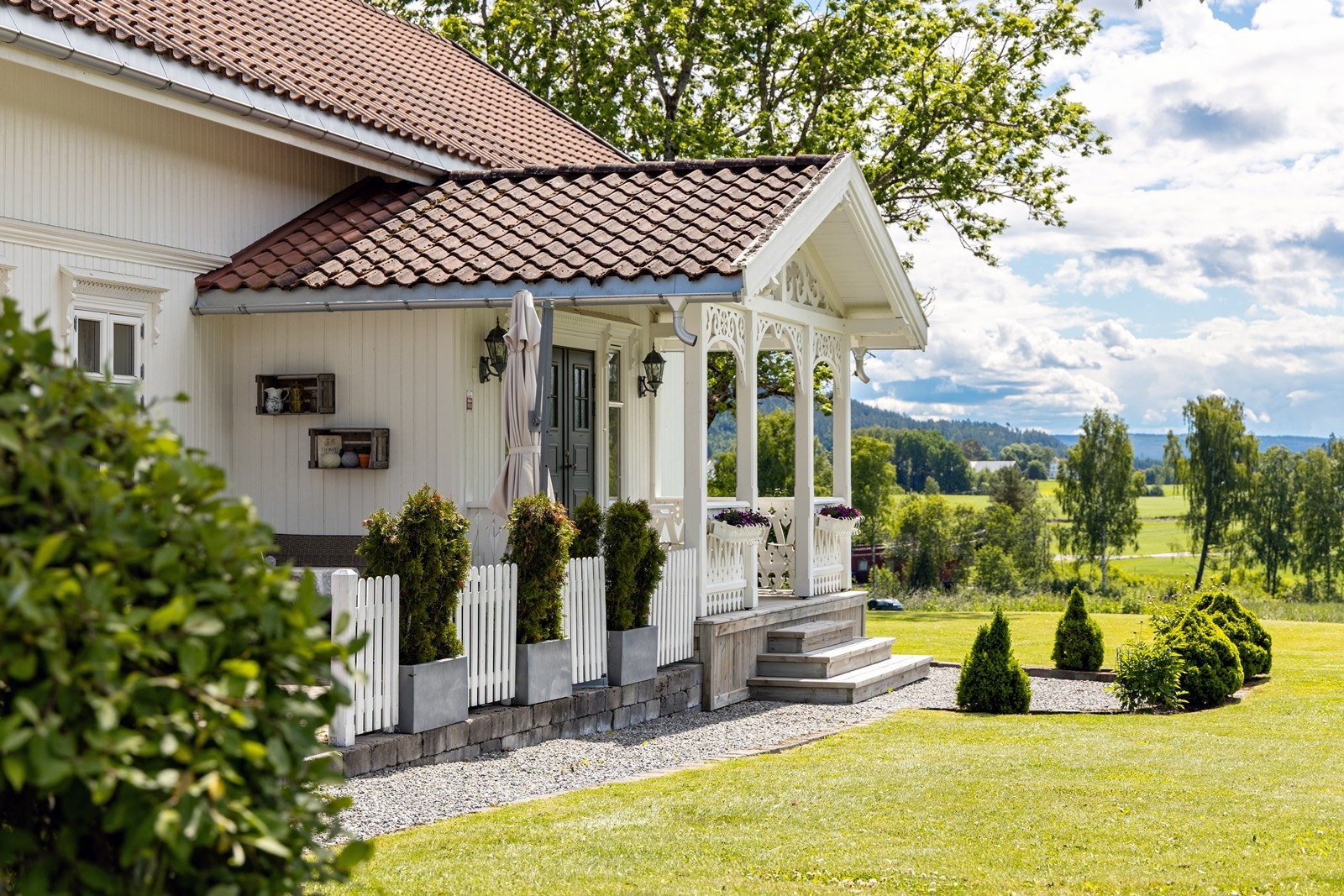 Hovedinngangen gir et flott førsteinntrykk, med elegante utelamper, vakre snekkergleder og overbygd ytterdør i tofløyet utførelse. Galleribilde