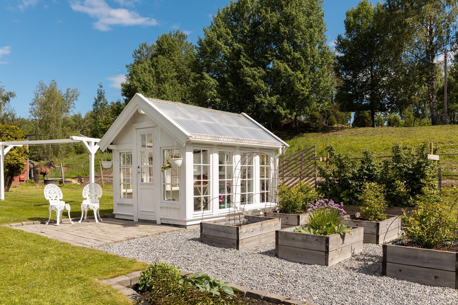 Det idylliske drivhuset har sprossevinduer og tilhørende blomsterkasser. Galleribilde