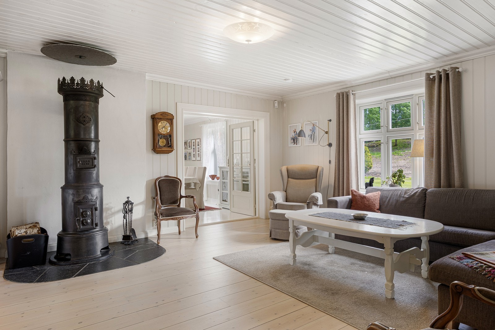 Den minste stuen benyttes i dag som tv-stue, perfekt for både familiehygge og sosiale kvelder i godt lag. Lune kvelder sikres av en klassisk etasjeovn med krone. Galleribilde