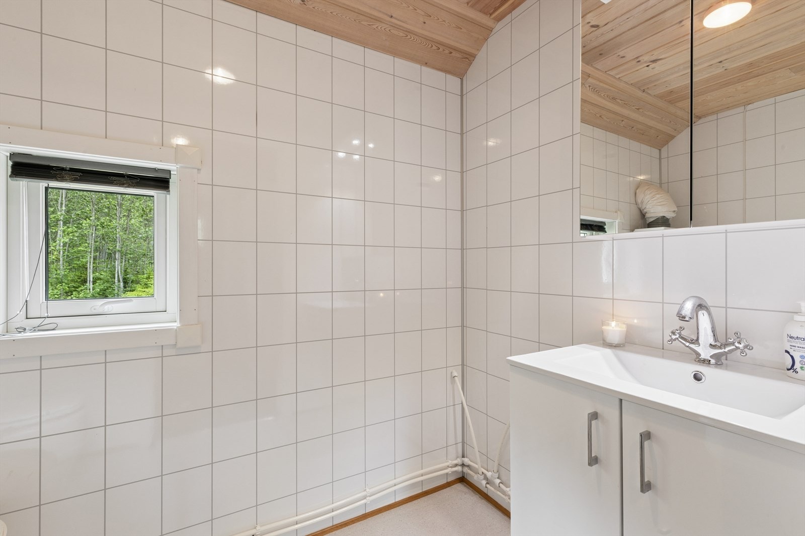 Toalettrom med våtromsplater på vegg og belegg på gulv. Galleribilde