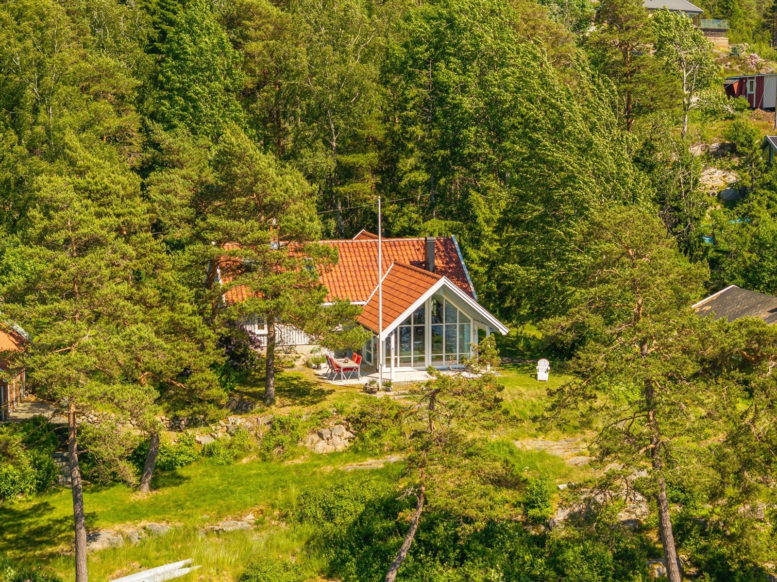 Naturlig vegetasjon med velvoksne trær gjør hytta lite fremtredende. Galleribilde