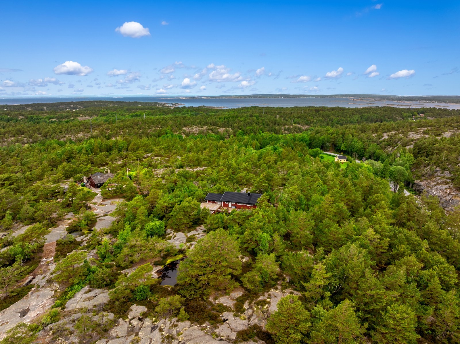 Ovenfra kommer naturtomten på 999,3 m² tydelig frem, med fjell i dagen, stedegen vegetasjon og terrassearealer rundt hytta. Galleribilde