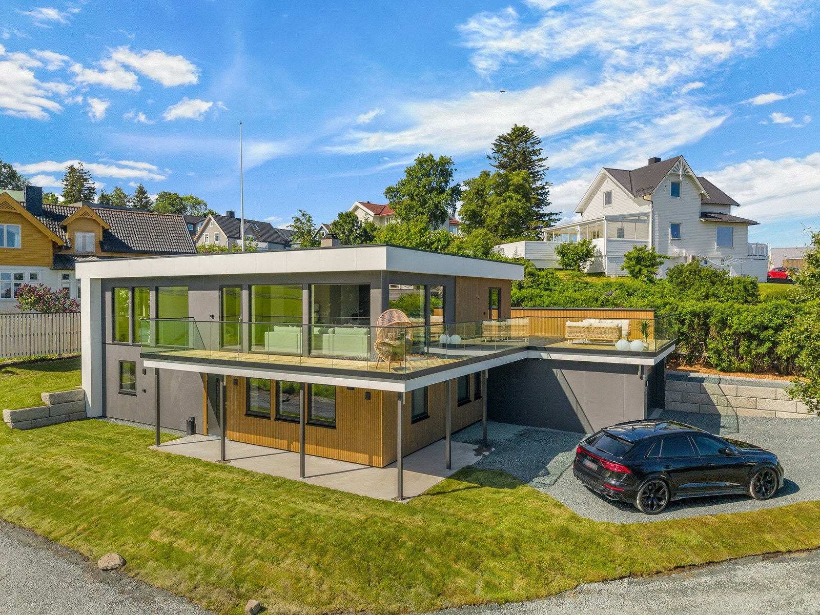 Tomten er pent opparbeidet både med murer, grus og plen. Galleribilde
