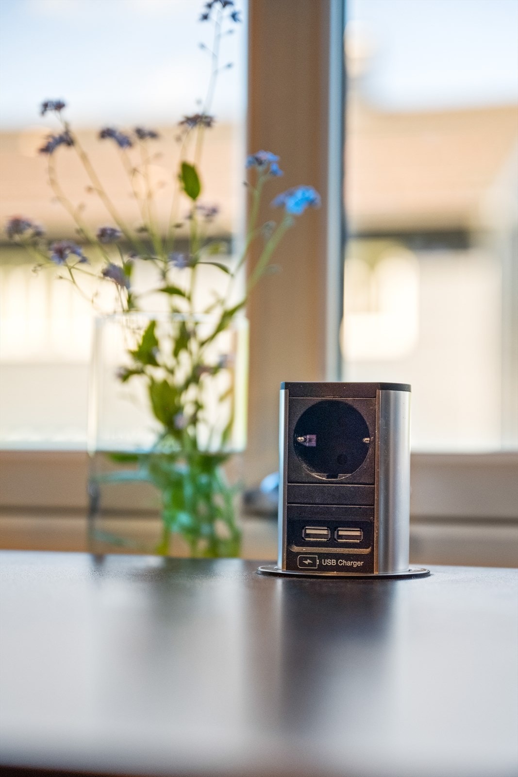 Praktisk, nedfellbar stikkontakt med USB-ladere er integrert i benkeplaten. Galleribilde