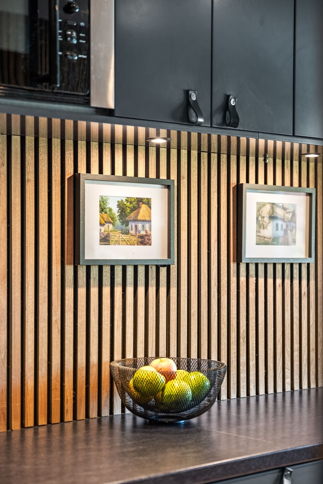 Spilevegg mellom benk og overskap, med integrert belysning. Galleribilde