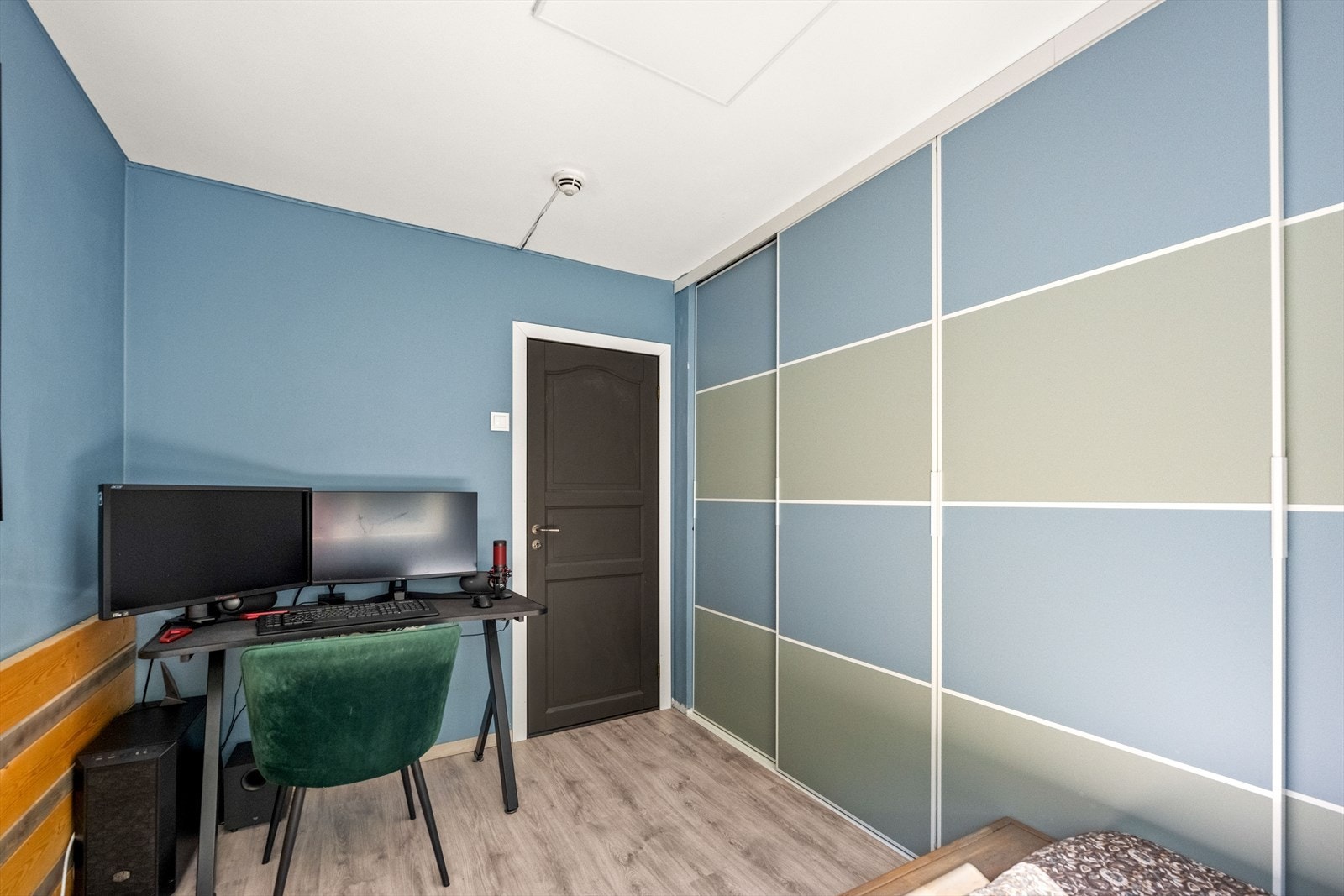 Et av to soverom i første etasje, med en stor skyvedørsgarderobe. Galleribilde