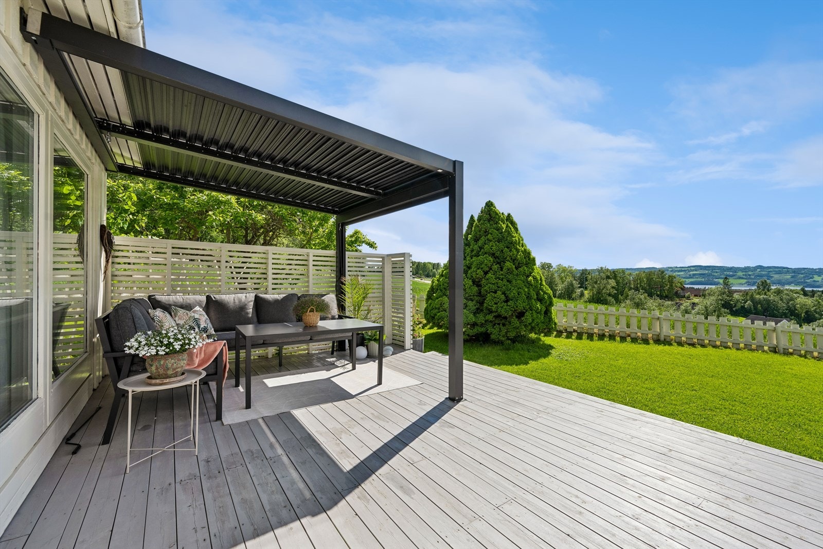 Sørvestvendt terrasse på 32 m² med pergola og utgang fra spisestuen. Galleribilde