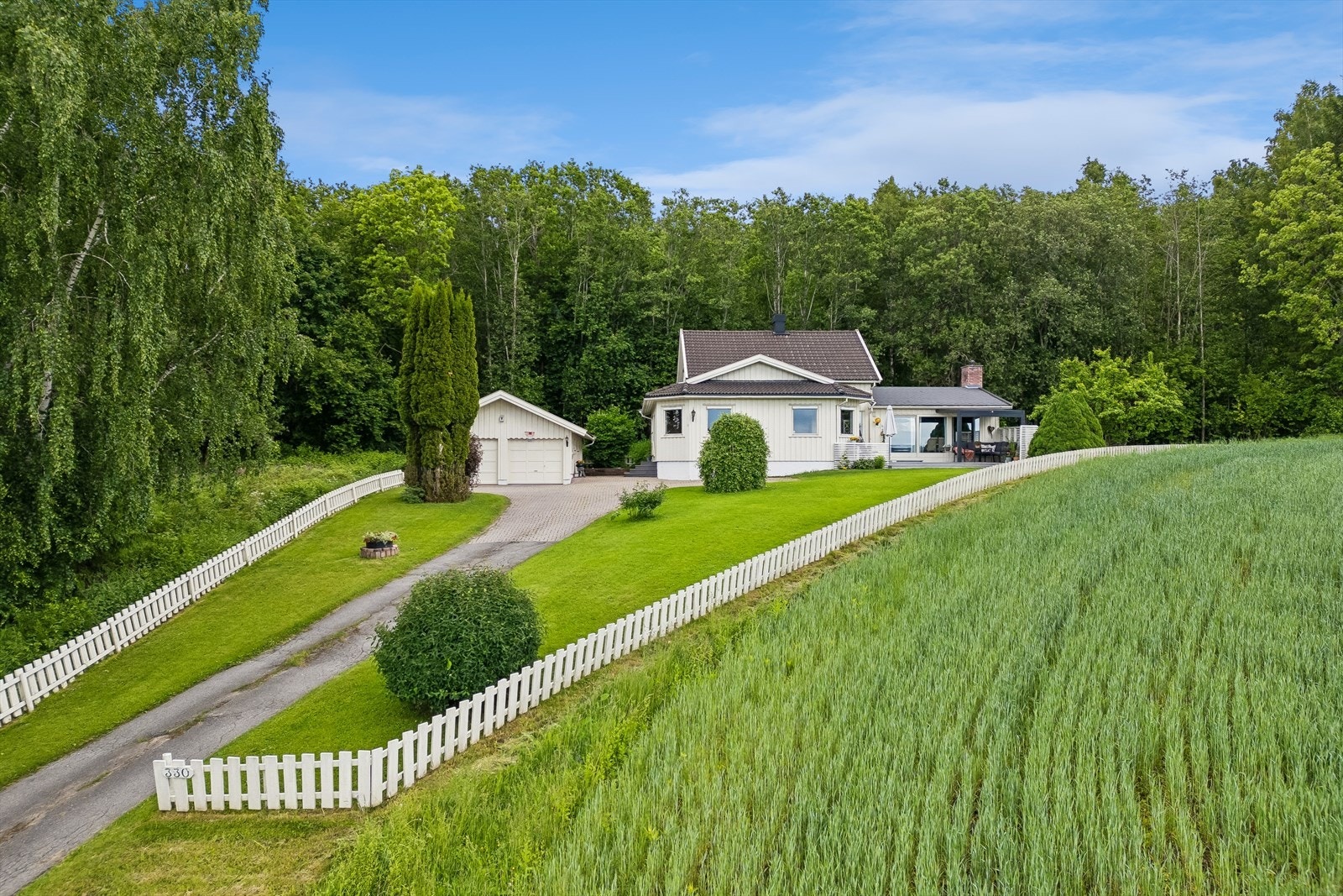 Eiendommen har en flat og opparbeidet tomt med plen og beplantning. Galleribilde