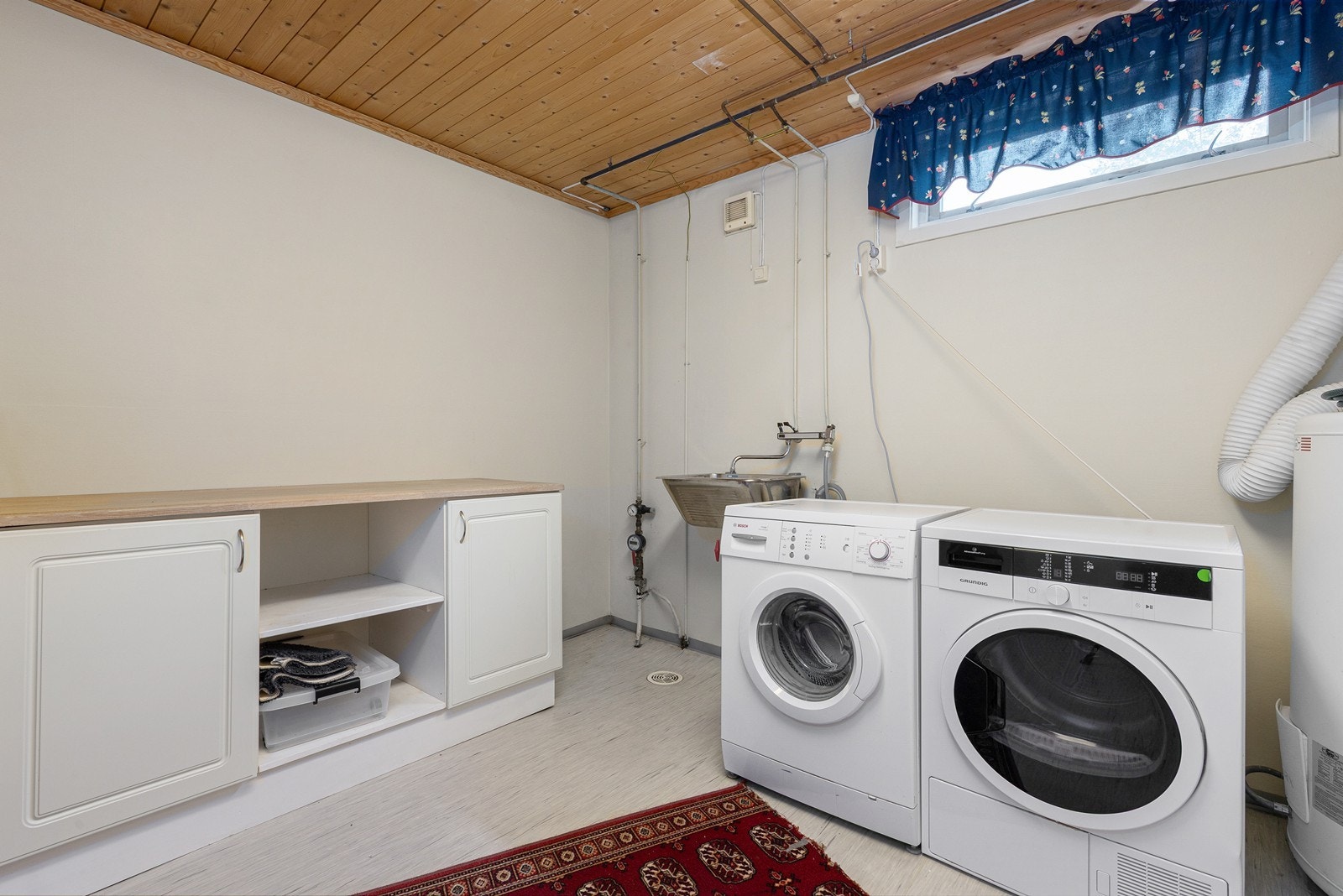 Praktisk vaskerom i kjelleren med utslagsvask og opplegg for vaskemaskin. Galleribilde