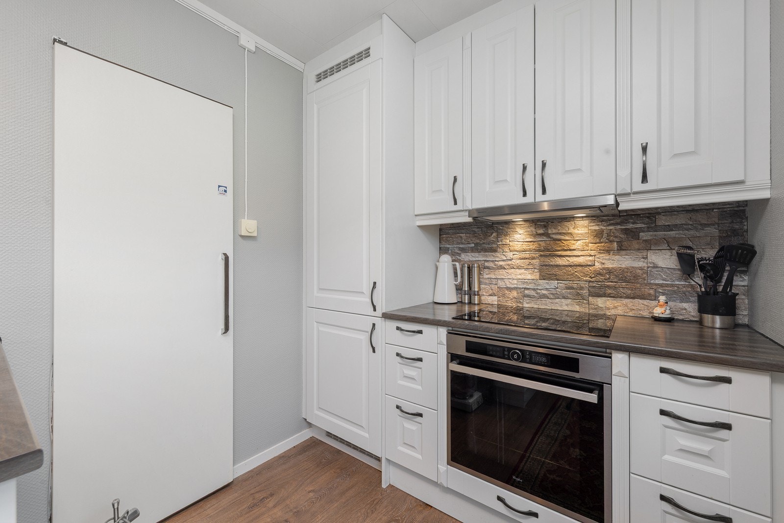 Kjøkkeninnredning fra Nybo (2014) med profilerte fronter og laminat benkeplate. Galleribilde