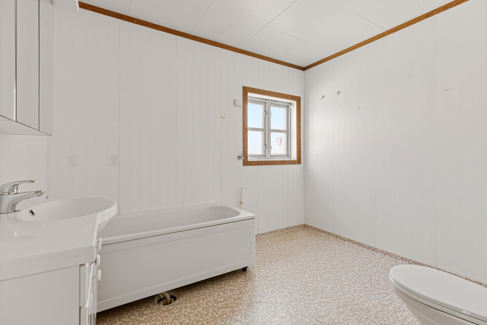 Baderommet er innredet med badekar, toalett og servant med lagring. Galleribilde