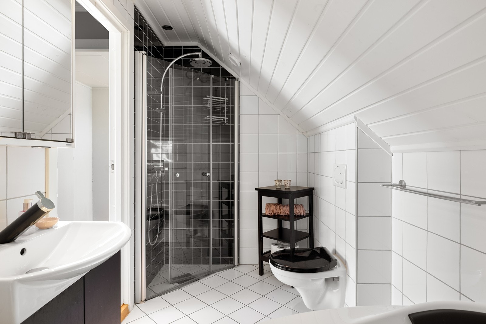 Badet er utstyrt med vegghengt klosett, dusjnisje i herdet glass og et herlig hjørnekar med dysefunksjoner. Galleribilde