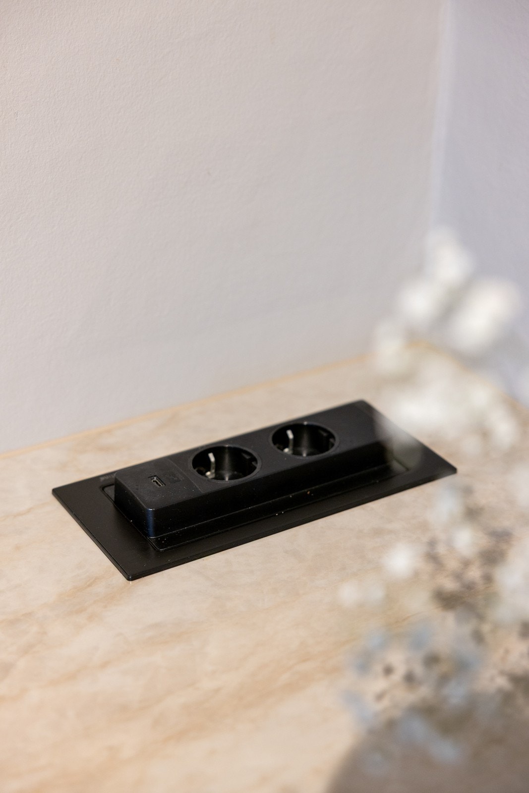 Benkeplaten er utstyrt med en stilren og innfelt pop-up-stikkontakt, som enkelt skyves ned når den ikke er i bruk for å bevare det minimalistiske uttrykket. Galleribilde