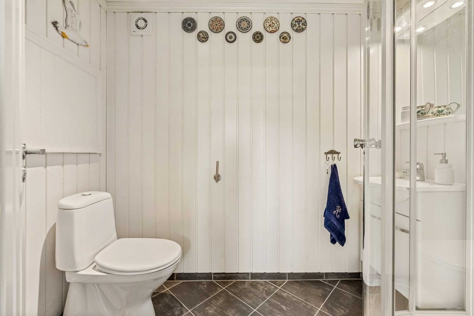 I uthuset finner vi dette badet. Innredet med gulvstående toalett, dusjkabinett og servant. Galleribilde