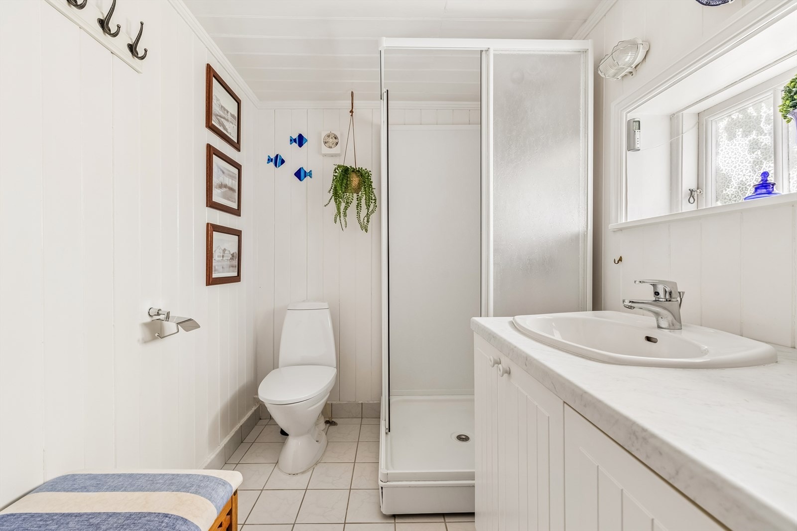 Badet er fra ca 2002. Rommet har innredning med nedfelt servant, gulvfestet toalett, dusjkabinett og opplegg for vaskemaskin. Her er det varmekabler i gulvet. Galleribilde