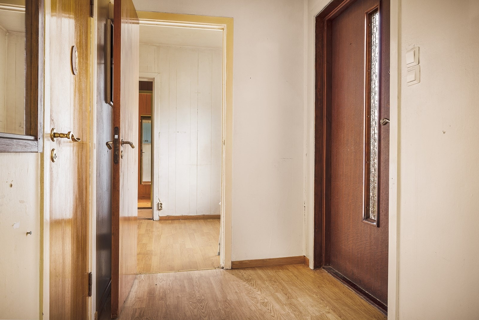 Entré med laminat på gulvet og tilgang til flere av boligens rom. Galleribilde