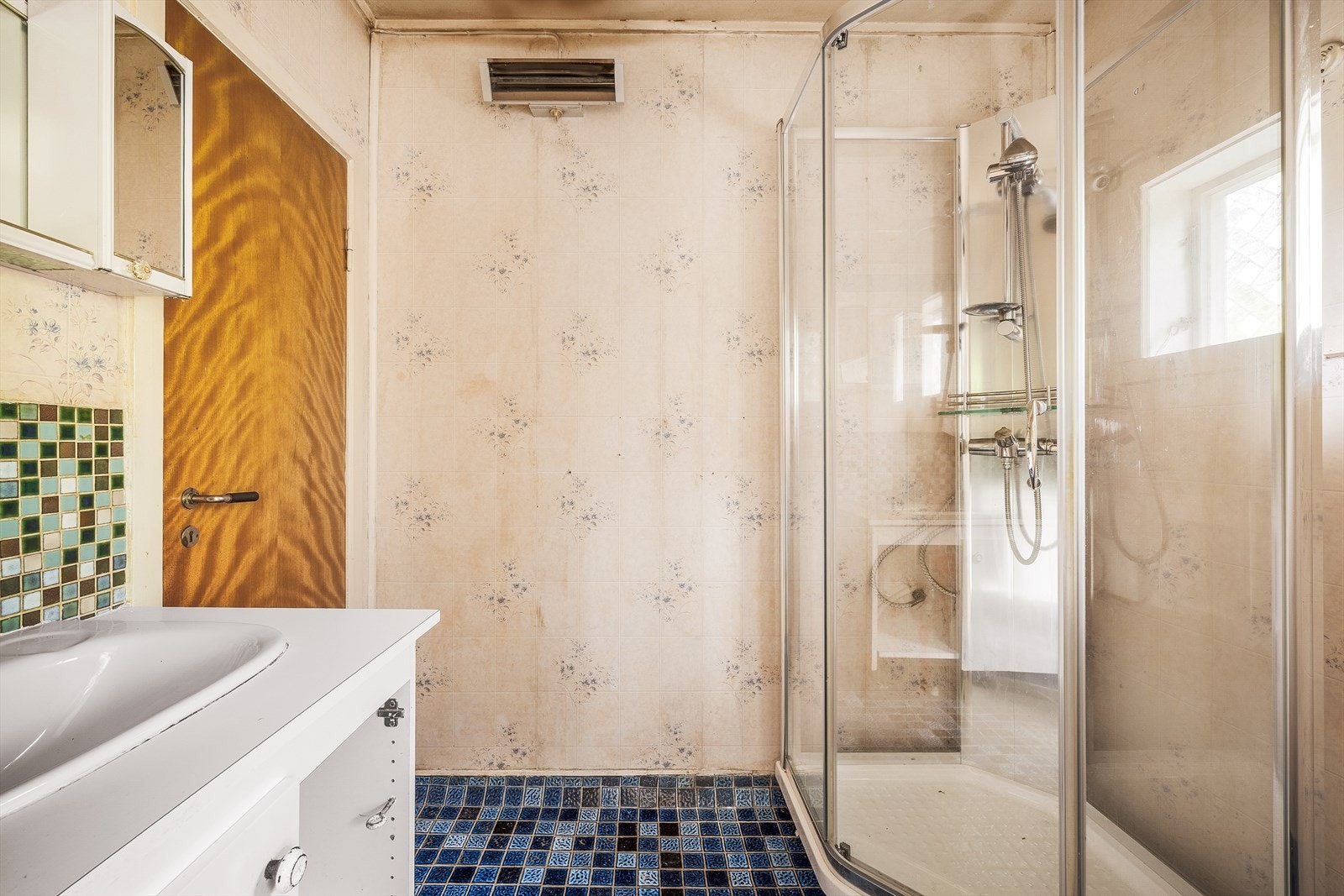 Badet er utstyrt med dusjkabinett, servant og keramiske gulvfliser. Galleribilde