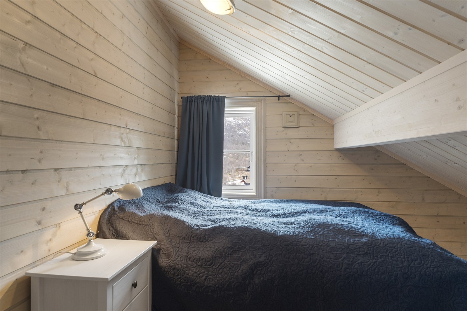 Etasjen har to soverom, begge med skråtak og trepanel på vegger og i himling. God plass til tre sengeplasser i begge soverommene. Galleribilde