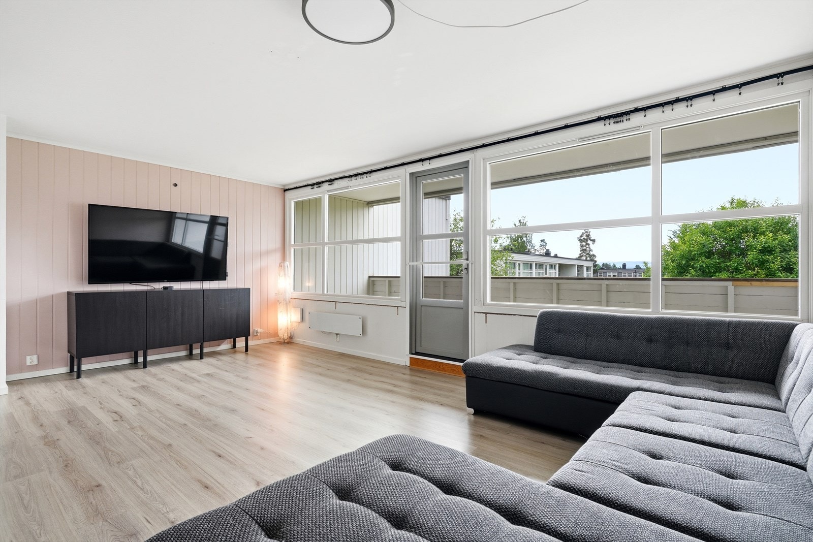 Gulvet i stuen er belagt med laminat, og veggene har malt strie og panelplater. Galleribilde