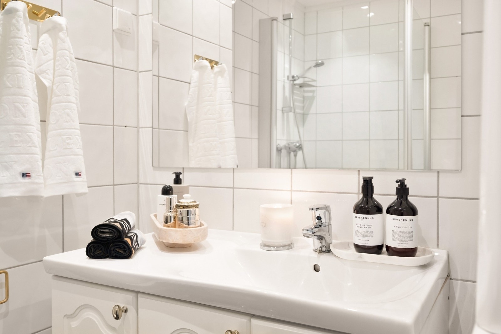 Badet er innredet med servantseksjon med skap, speil over servant, dusjhjørne med inn-/utadslående dører i herdet glass og gulvmontert toalett. Galleribilde