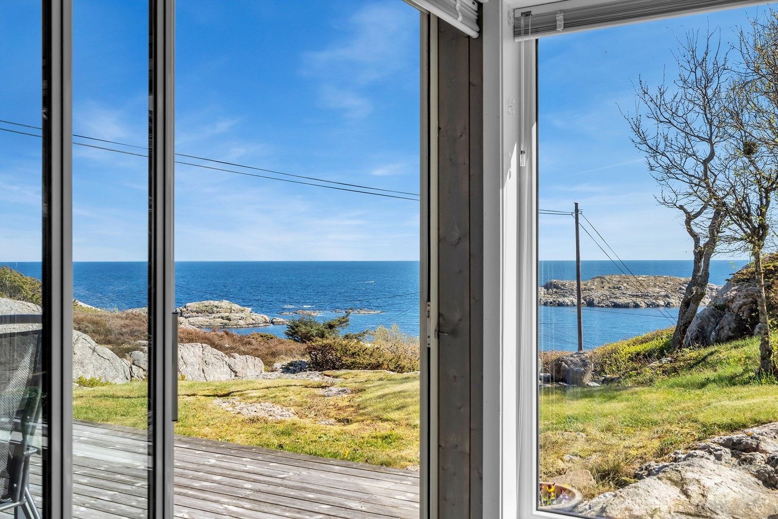 Utsikt fra hagestuen mot terrassen og det åpne havet. Galleribilde