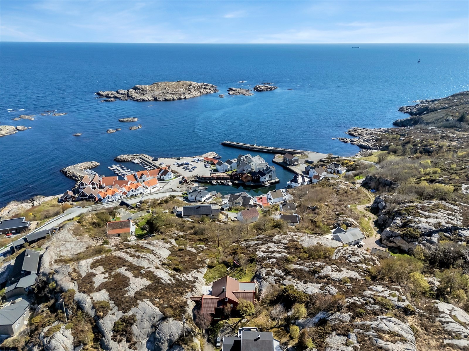 Fra luften ser man hyttas unike plassering med nærhet til både havna og det åpne havet. Galleribilde