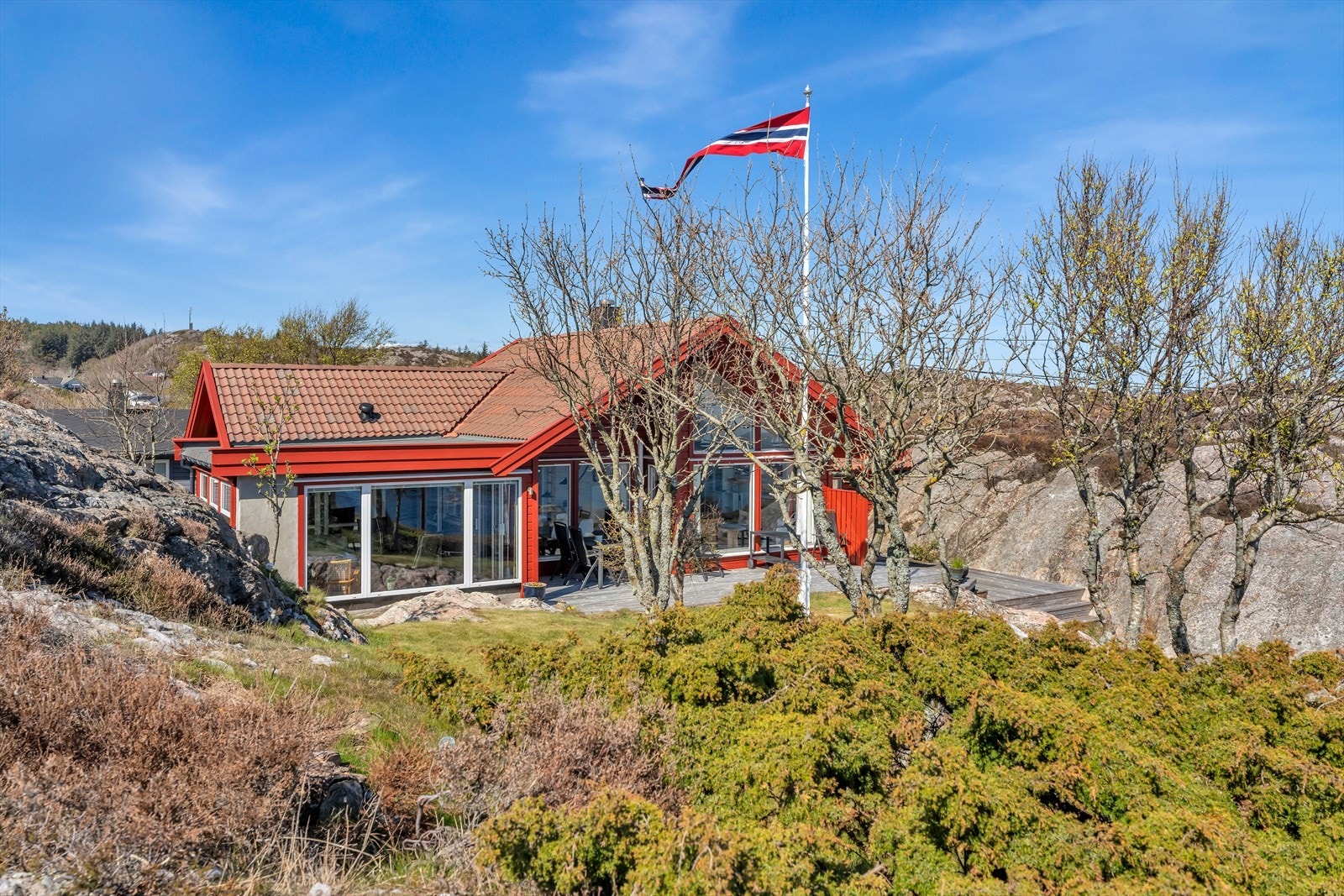 Hytta glir naturlig inn i det kuperte kystlandskapet. Galleribilde