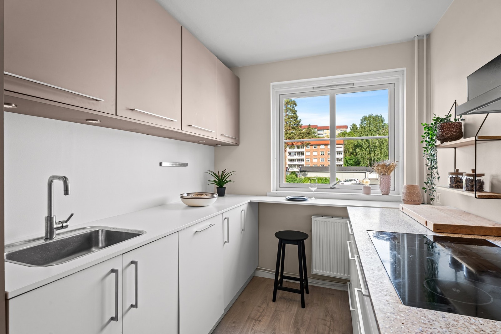 Kjøkkenet er moderne og praktisk med innredning fra KVIK, glatte fronter i hvitt og gråbrunt, og benkeplater i laminat og steinkompositt Galleribilde