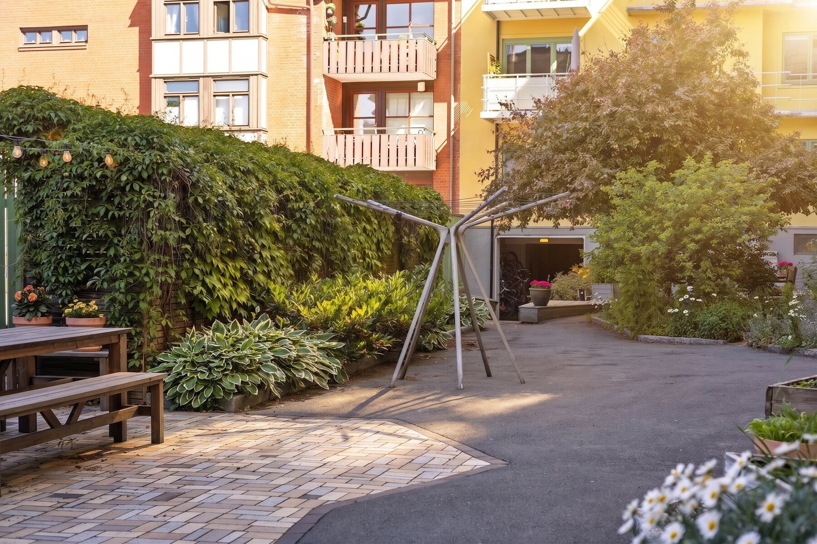 Bakgården har også felles tørkestativ og det beplantes med spiselige arter som gulrøtter, rødbeter, sukkererter og diverse urter som fritt kan benyttes av beboerne. Galleribilde