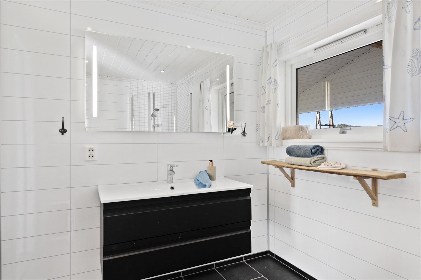 Badet er innredet med nedfelt servant, dusjhjørne og toalett Galleribilde