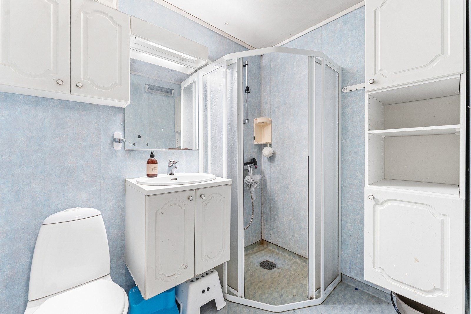 Badet har gulvbelegg og baderomsplater på veggene. Badet er innredet med toalett, dusjhjørne og baderomsinnredning med vask. Galleribilde