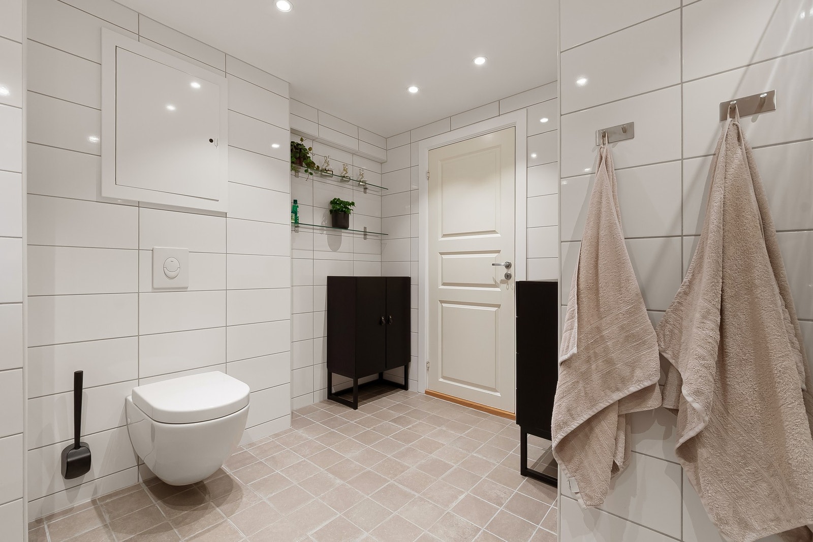 Badet er utstyrt med dusjhjørne, innfellbare dusjdører, servant, veggmontert WC og opplegg for vaskemaskin. Galleribilde