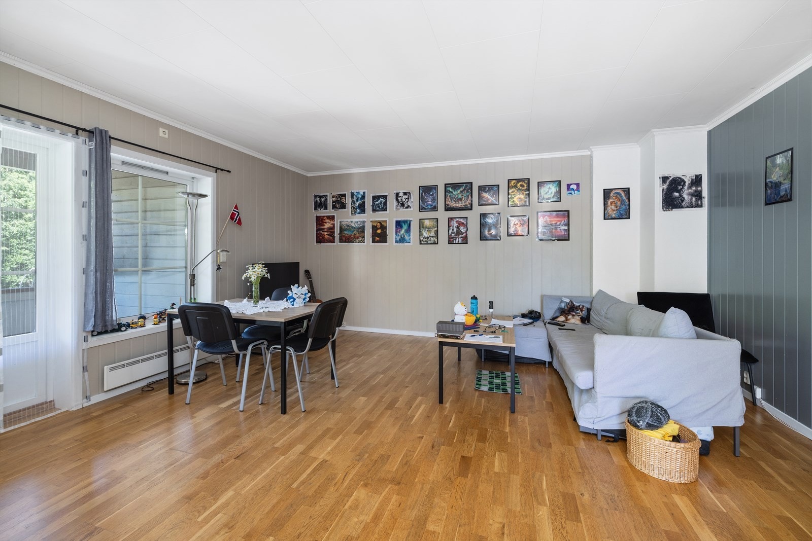 Stue med parkett på gulv og utgang til privat, takoverbygget veranda. Galleribilde