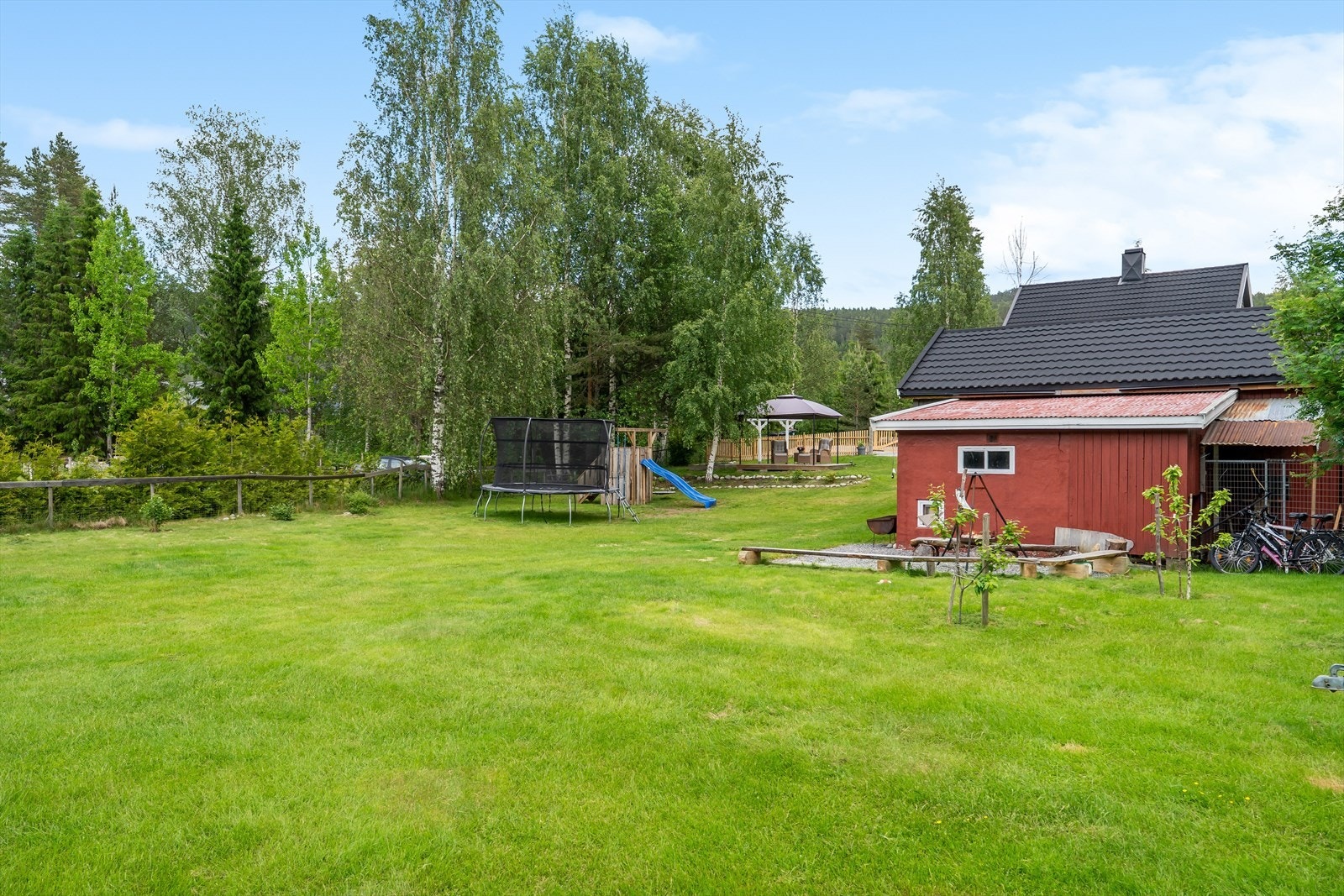 Barnevennlig uteområde med god plass til trampoline, lekeapparat og hyggelig sitteplass Galleribilde