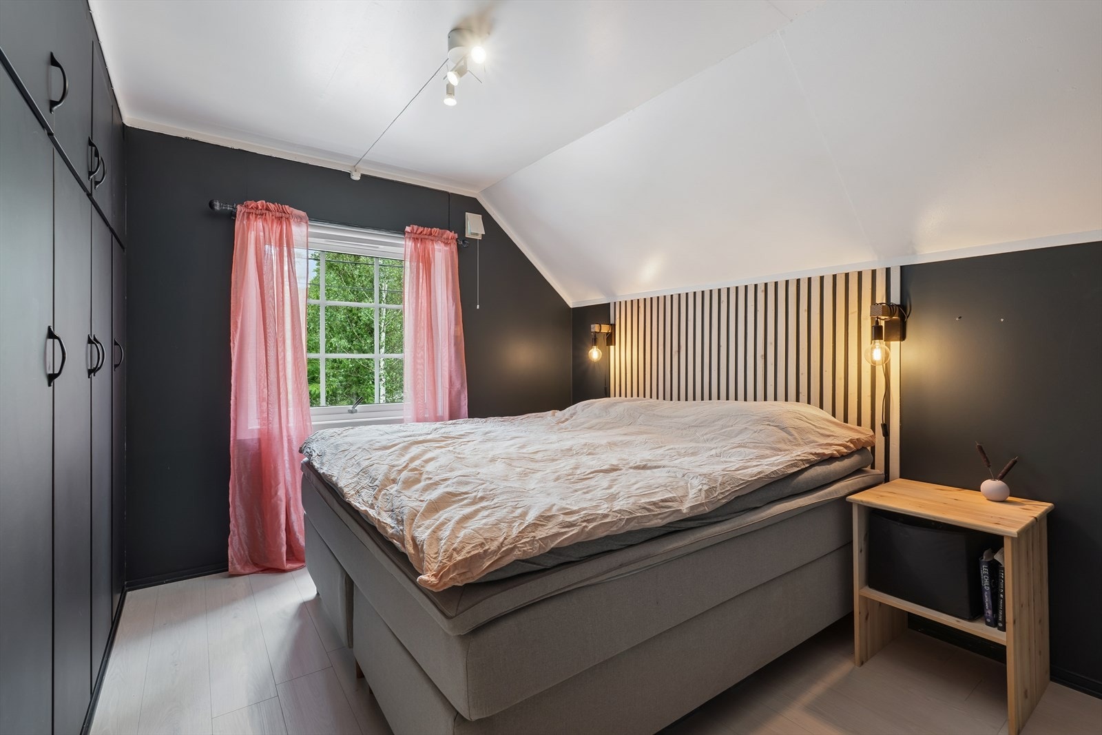 Hovedsoverom med mørke, lune fargetoner, praktisk garderobeløsning og behagelig lys fra vindu. Galleribilde