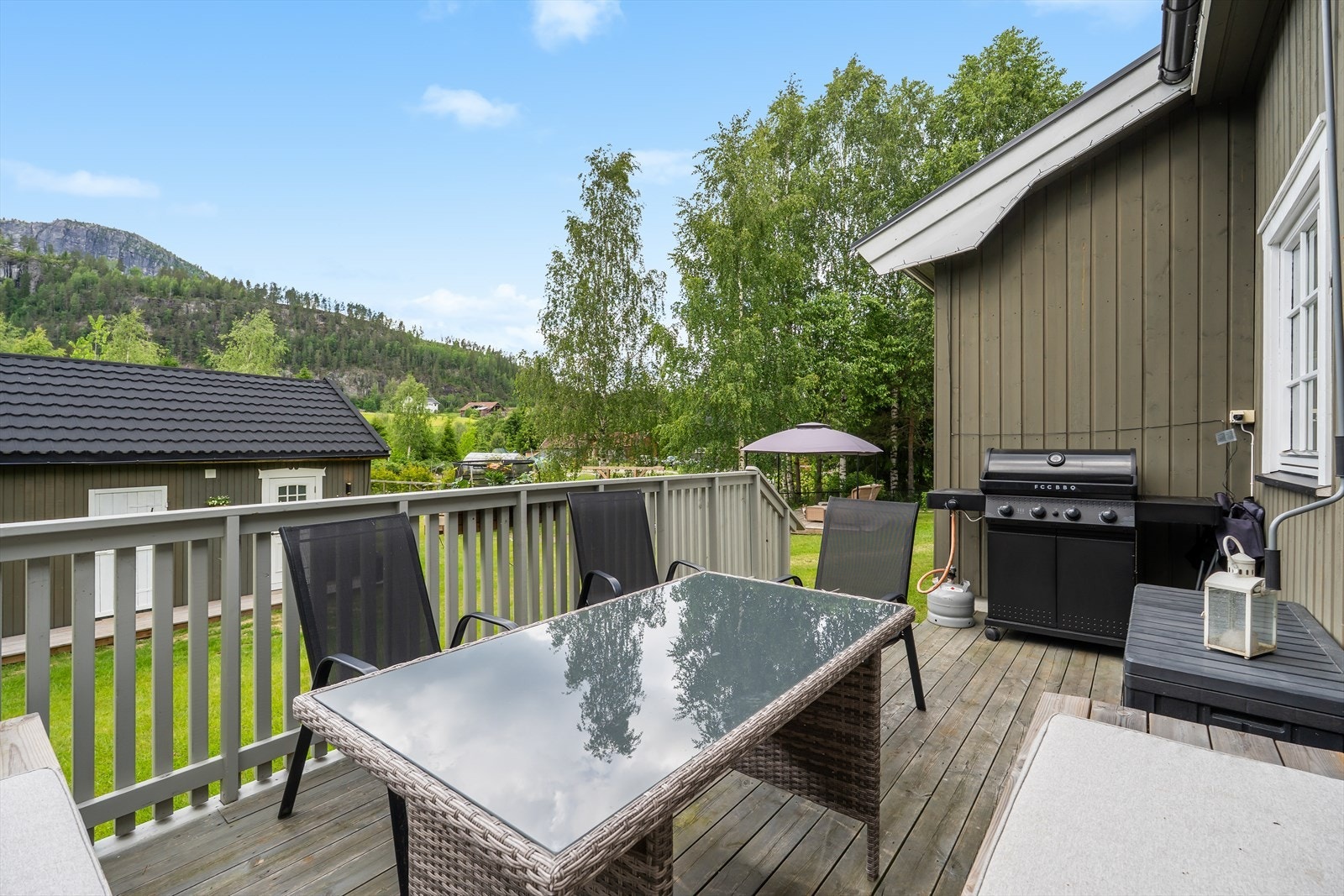 Solrik terrasse med plass til sittegruppe og grill - et perfekt sted for hyggelige måltider og sosiale sammenkomster Galleribilde
