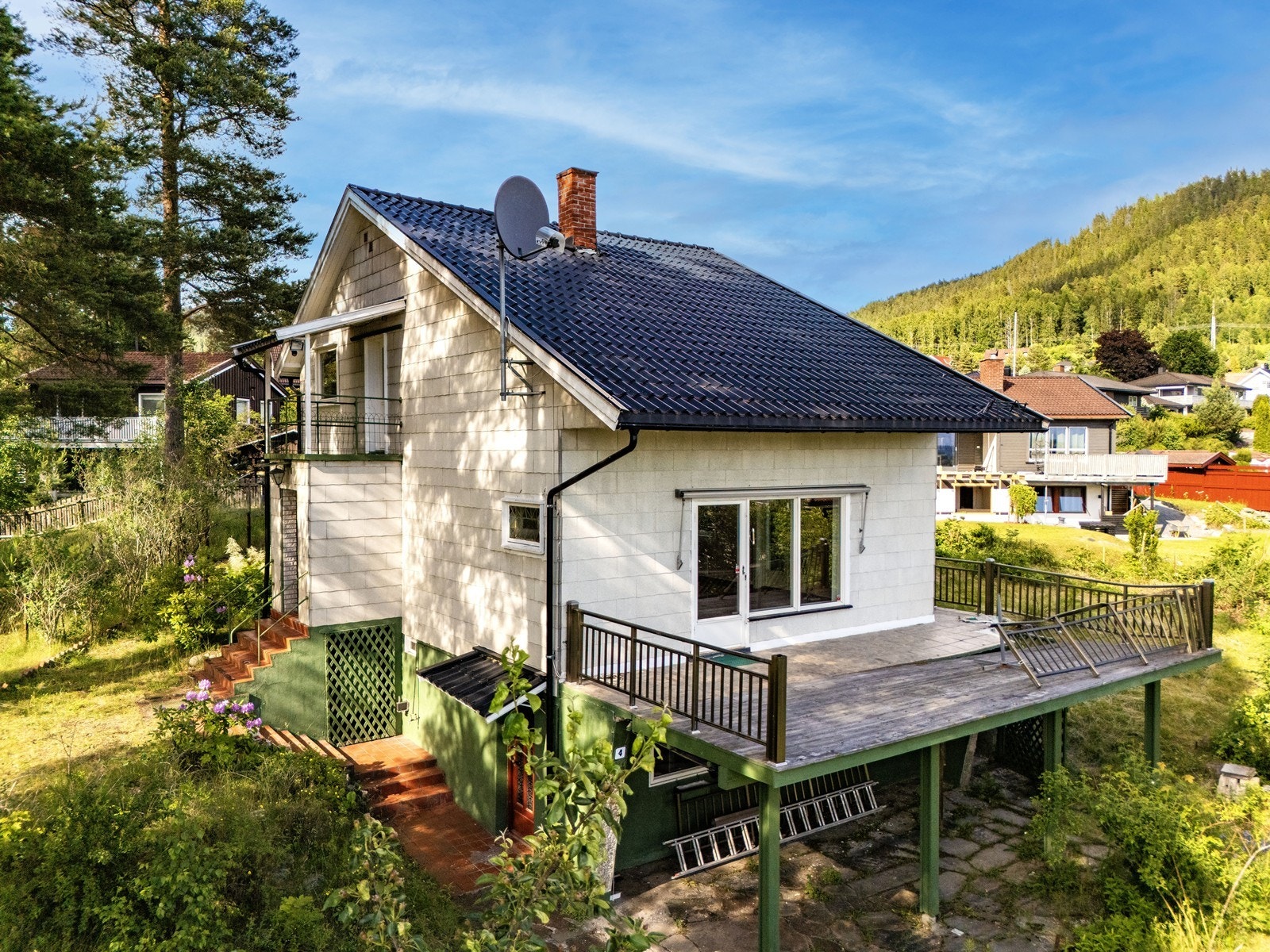 Oversikt over eiendommen med bolighus og frittstående garasje. Galleribilde