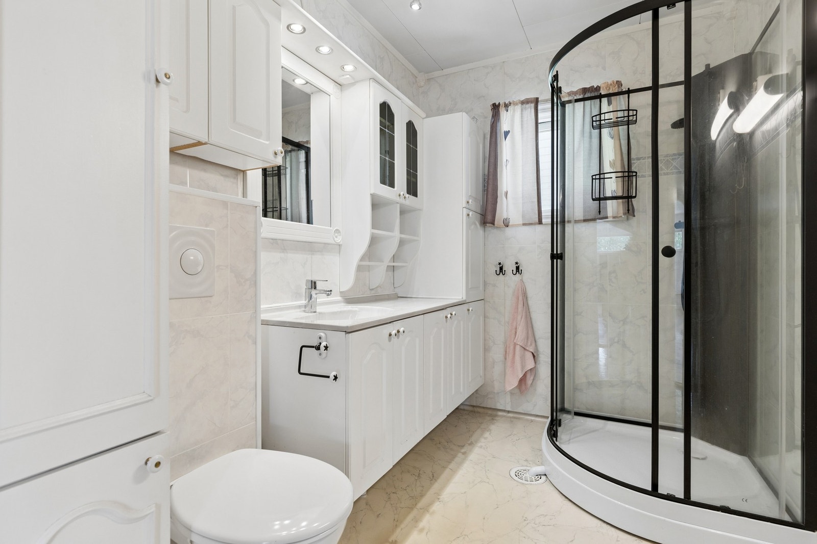 Badet i hovedetasjen er utstyrt med dusjkabinett og servant med oppbevaring. Galleribilde