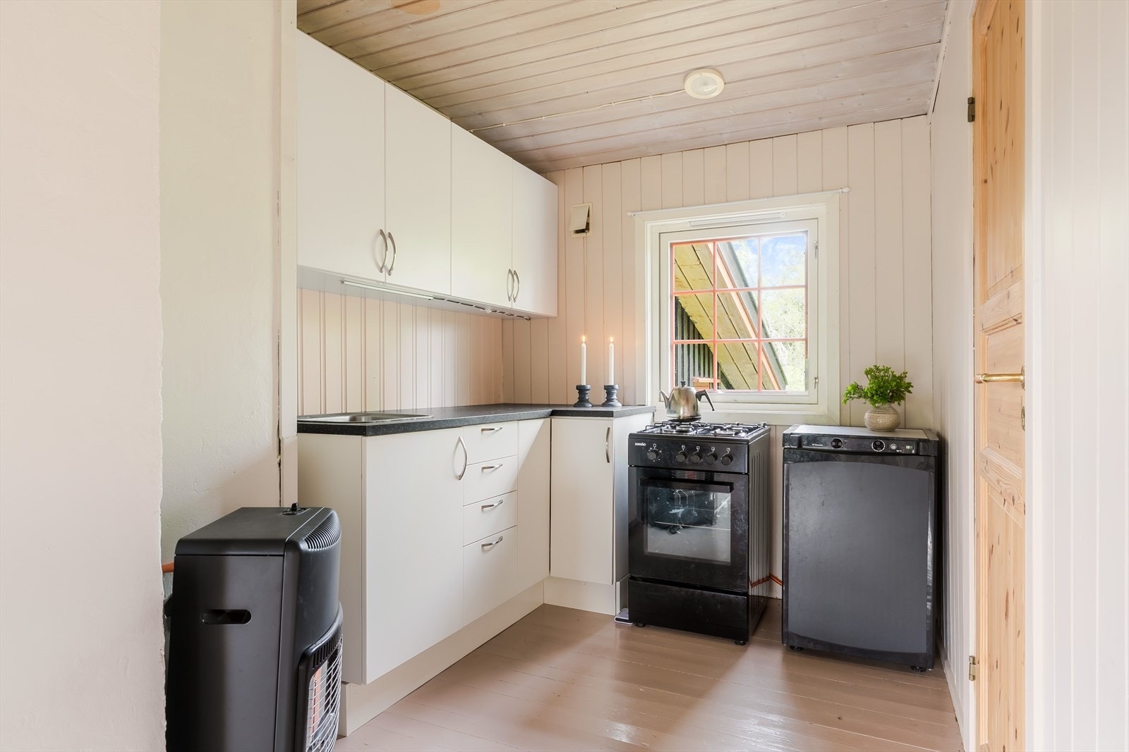Det trivelige kjøkkenet ligger i en egen krok - adskilt fra stuen, men likevel i en åpen løsning. Her har man fin oppbevaring i både under- og overskap, laminert benkeplate samt nyere hvitevarer på gass. Galleribilde