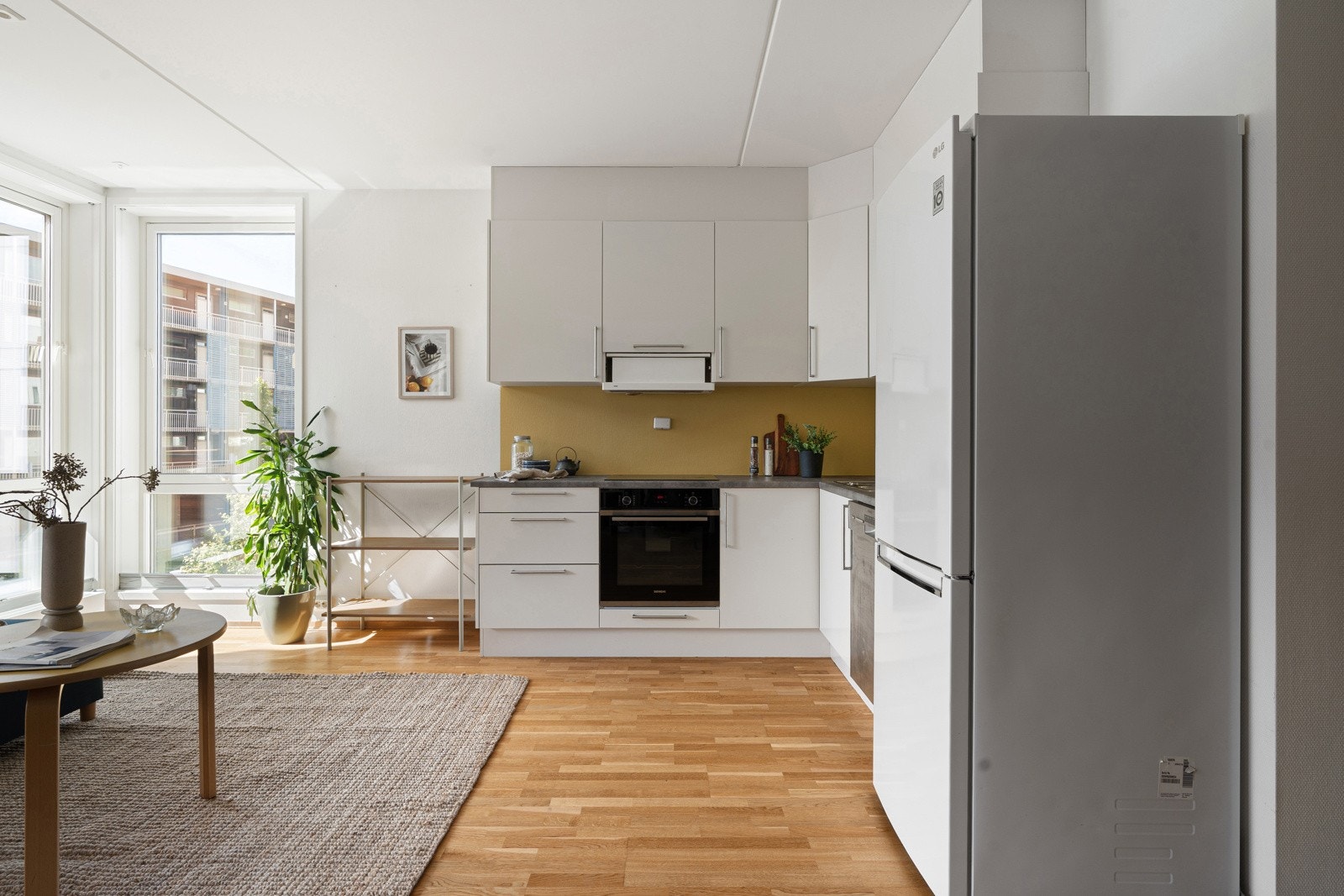 Kjøkkenet har innredning med lyse slette fronter og plass til frittstående hvitevarer.