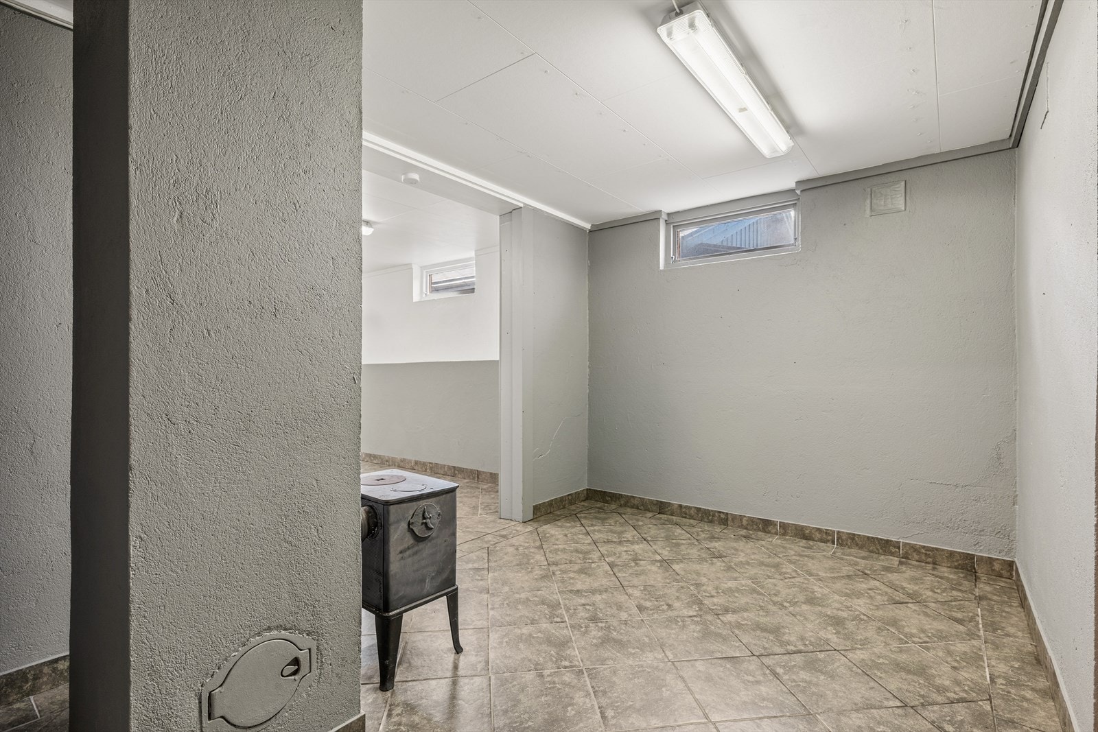 I kjellerens garasjerom er det installert en vedovn. Galleribilde