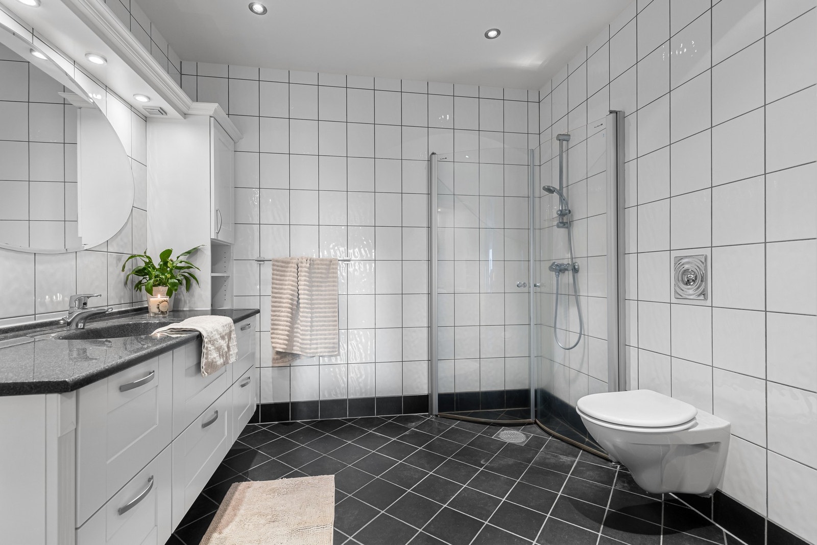 Badet tilknyttet hovedsoverommet har dusjvegger, veggmontert toalett. Begge badene fremstår som velholdte og innbydende, med klassisk innredning som byr på rikelig oppbevaringsplass, profilerte fronter og heldekkende servant. Galleribilde