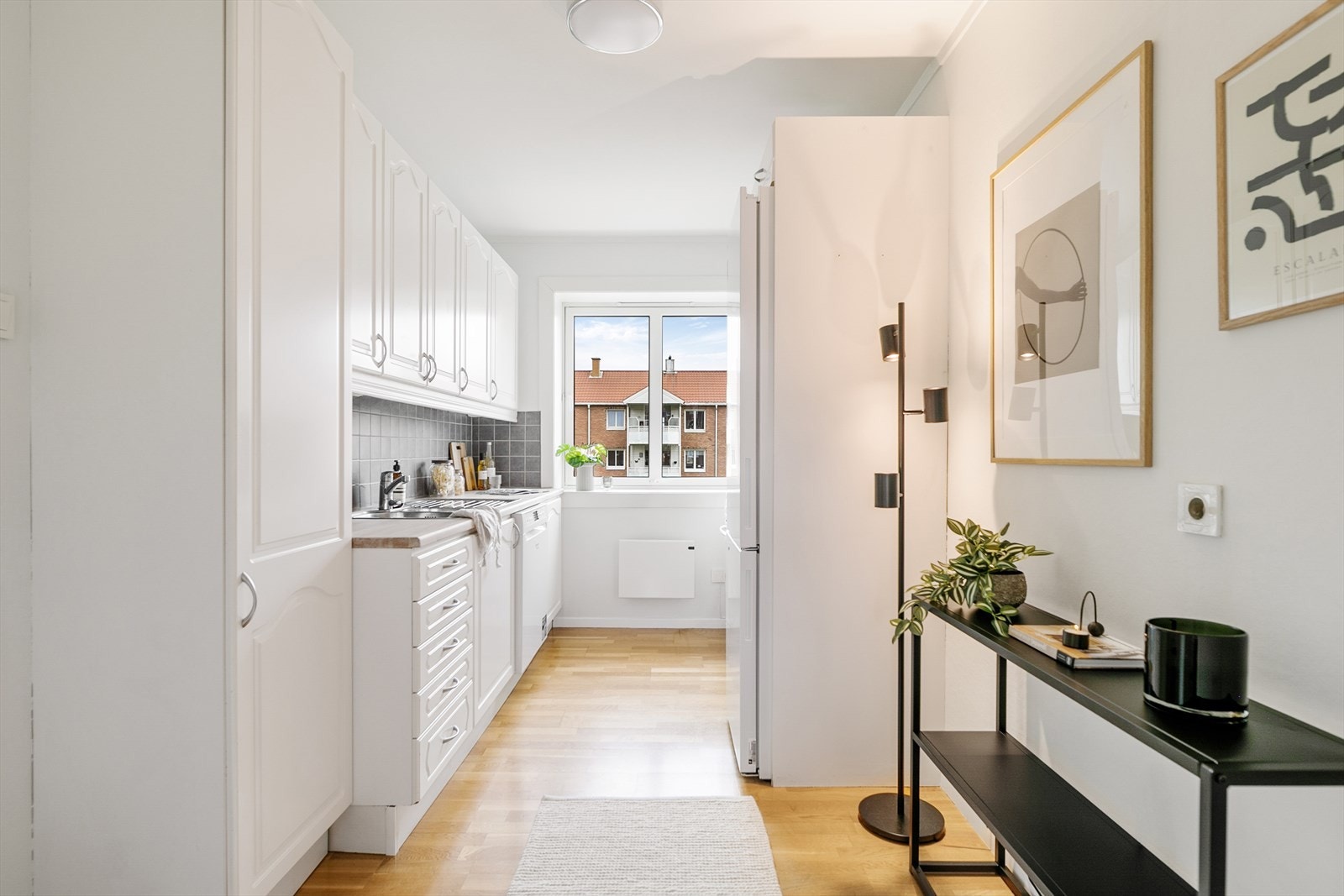 Praktisk kjøkken i eget rom med vindu som slipper inn morgensolen. Galleribilde
