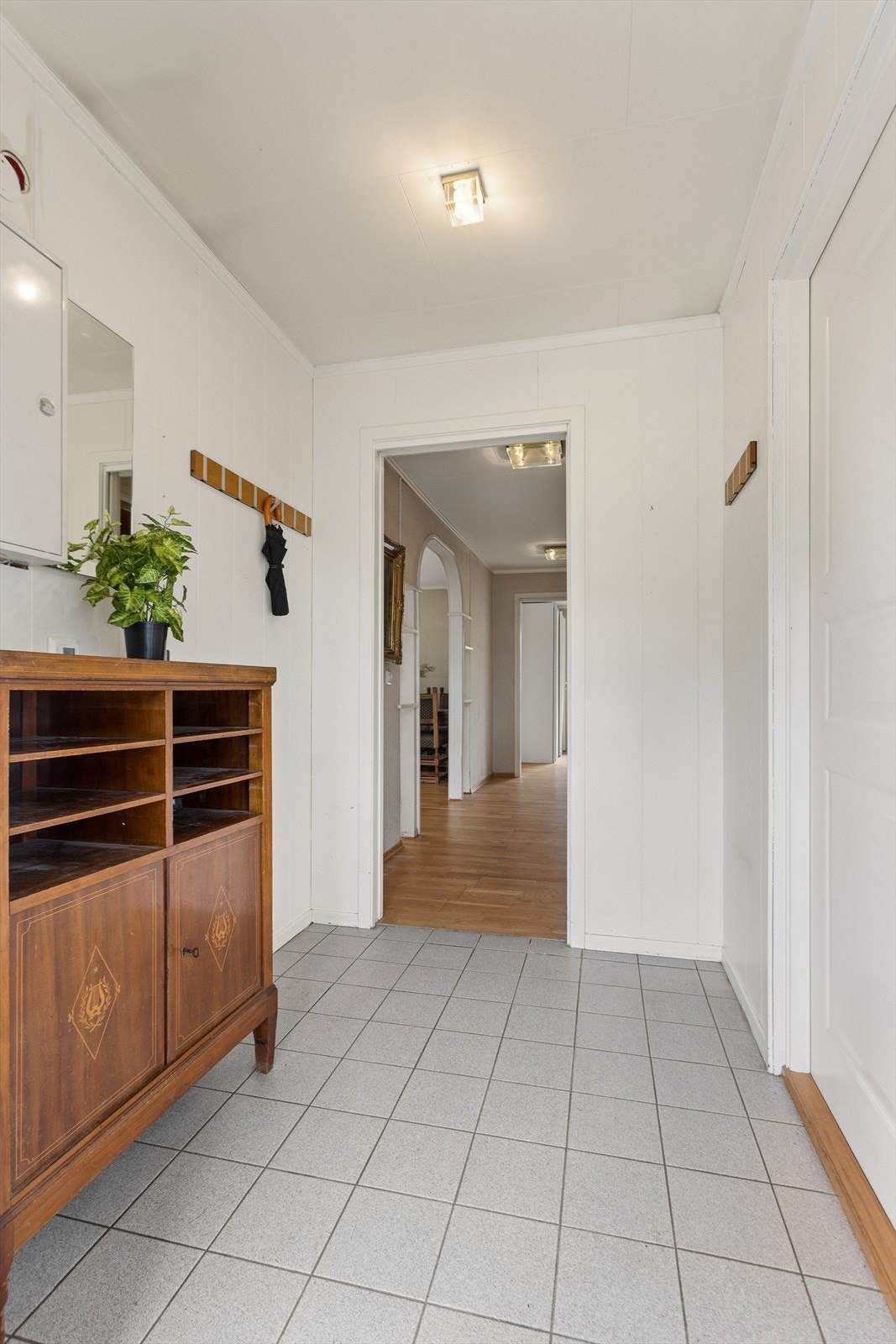 Velkommen inn! Entréen gir et praktisk første møte med boligen og har adkomst til ett av boligens soverom. Herfra ledes du videre inn til den romslige hallen, som binder sammen boligens øvrige rom. Galleribilde