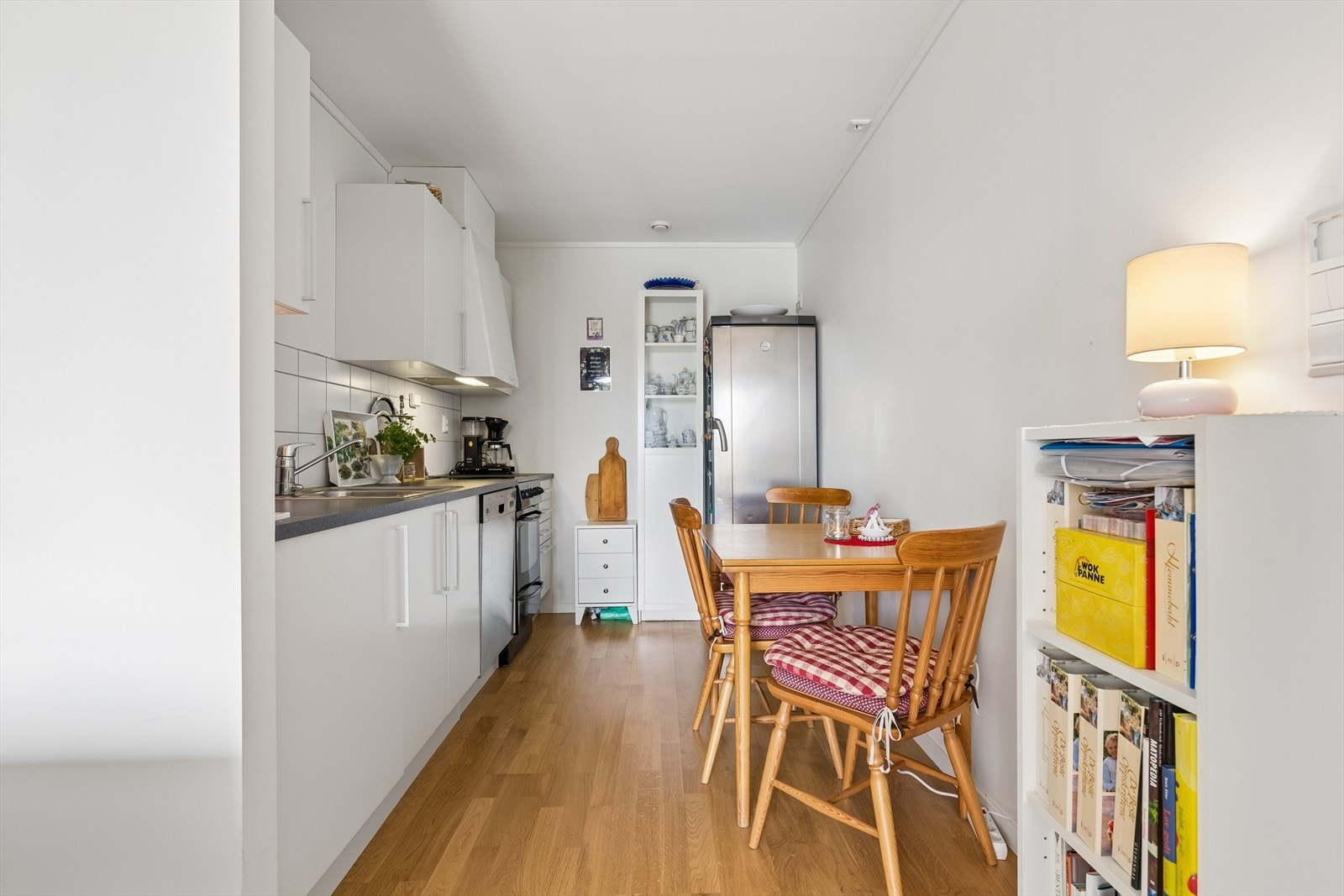 Kjøkkenet i leiligheten har slette fronter, laminatbenkeplate og plass til spisebord. Galleribilde
