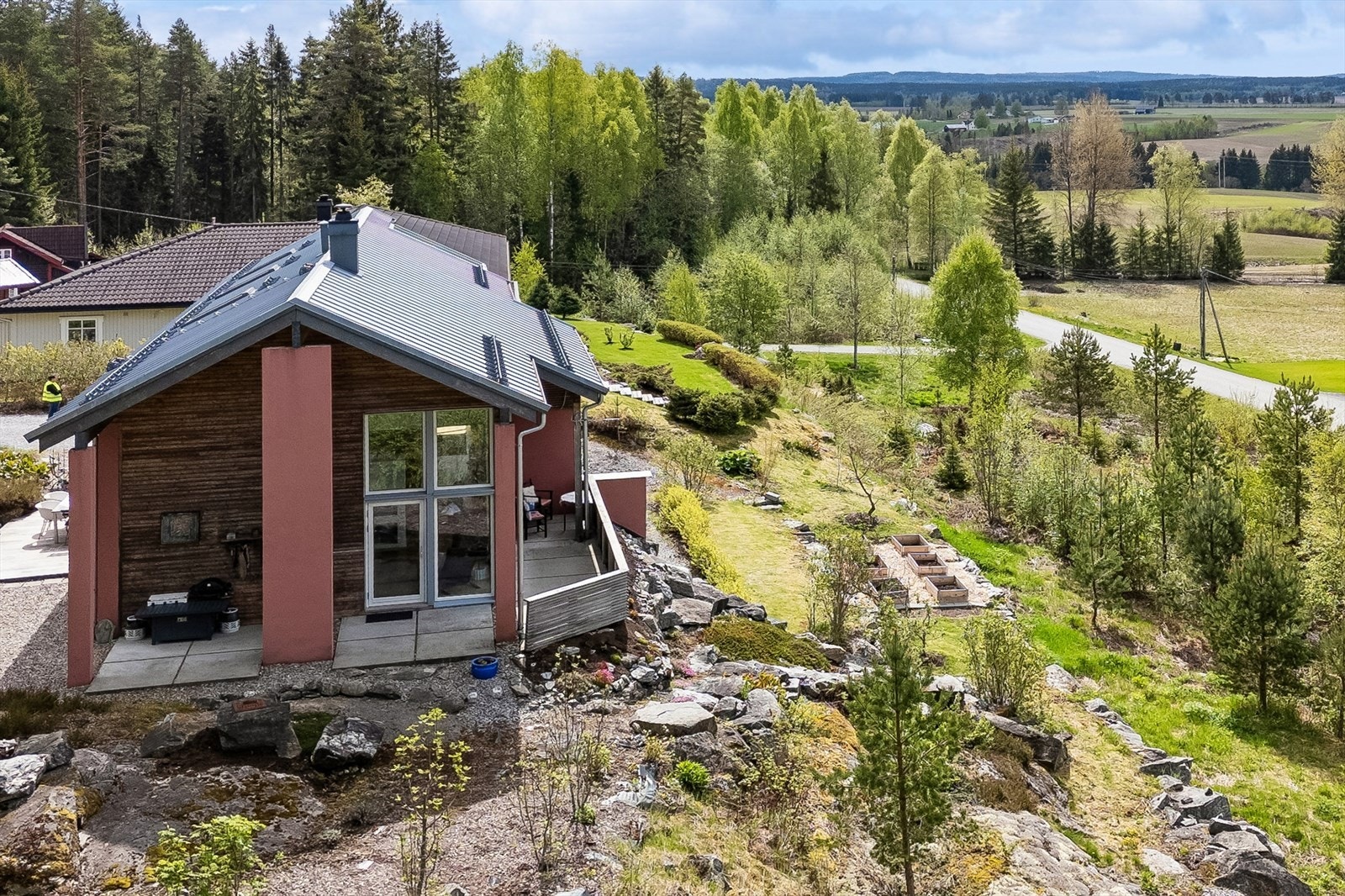 Eiendommen ligger i et lett skrånende terreng med forstøtningsmurer og trapp i naturstein. Galleribilde