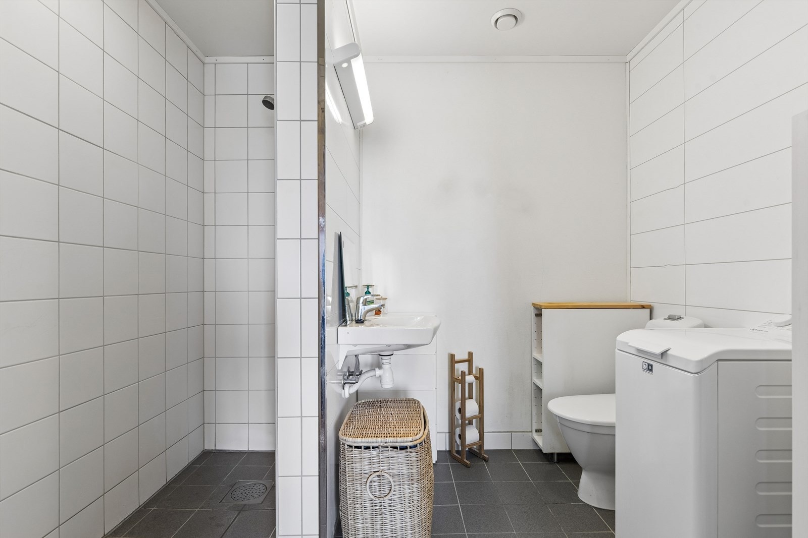 Badet i leiligheten har flislagt gulv med varme, dusjnisje og opplegg for vaskemaskin. Galleribilde