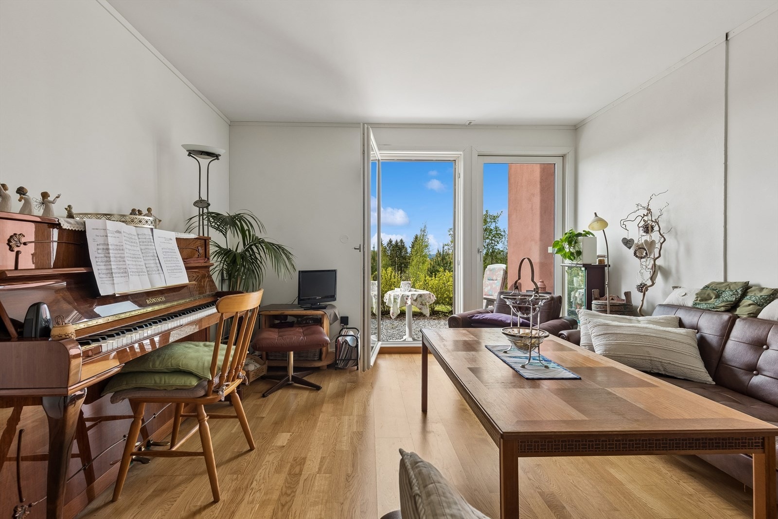 Stuen i sokkelleiligheten har plass til sofagruppe og utgang til uteplass. Galleribilde