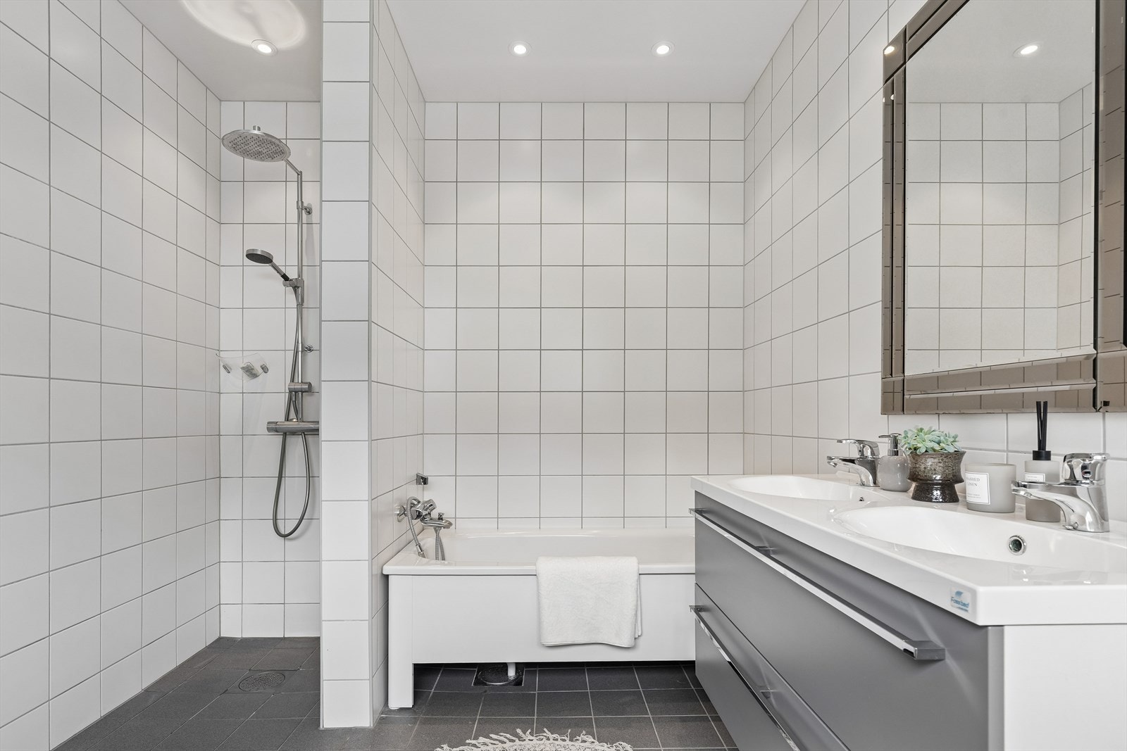 Badet er utstyrt med både badekar og dusj, dobbel servant og vegghengt toalett. Galleribilde