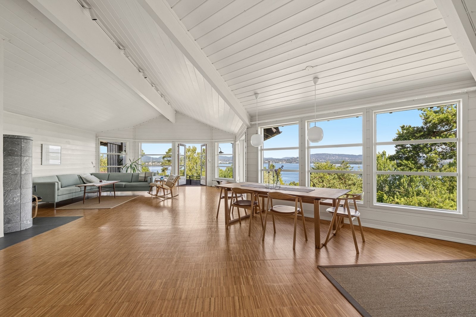 Stuen fremstår som husets naturlige midtpunkt, med imponerende takhøyde, rikelig lysinnslipp fra store vindusflater og en fantastisk utsikt som trekkes inn i rommet. Galleribilde